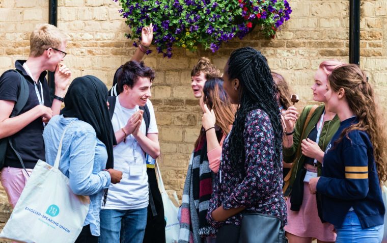 A group of debate academy students (male and female) gathered outside the building.