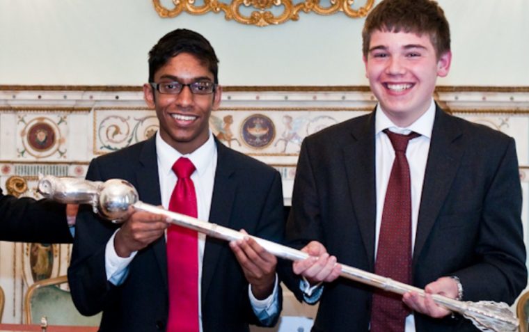 A picture of Tommy and peer holding the School's Mace winners, 2012 staff.