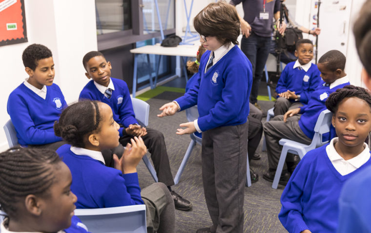 Primary school pupils gathered inside a classroom