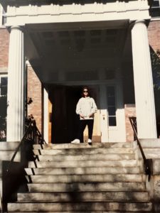 A picture of Sarah Harding Moses standing at the entrance of a building wearing sunglasses.