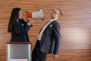 woman shouting at man through megaphone