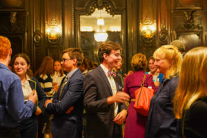 People laughing and smiling while talking inside Dartmouth House