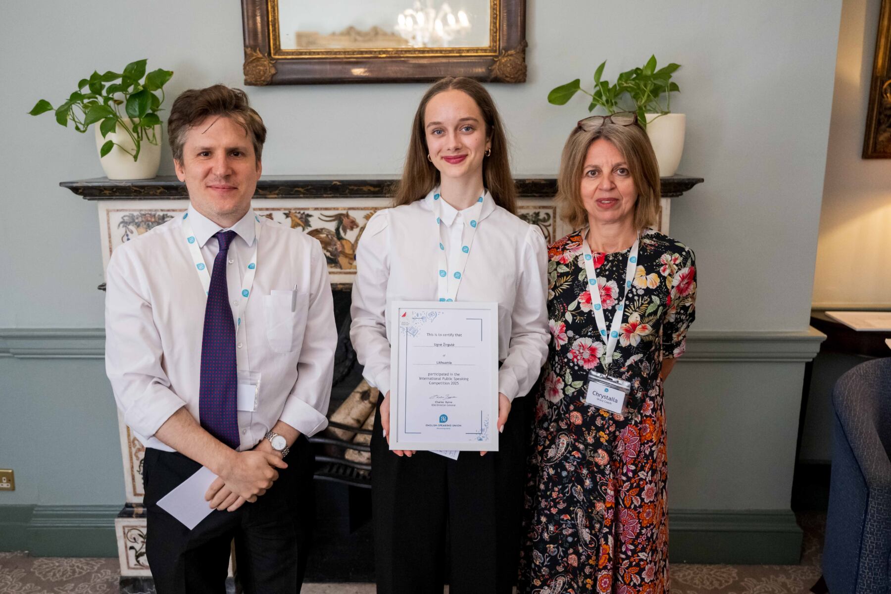 Woman with a certificate standing with a man to her left and a woman to her right