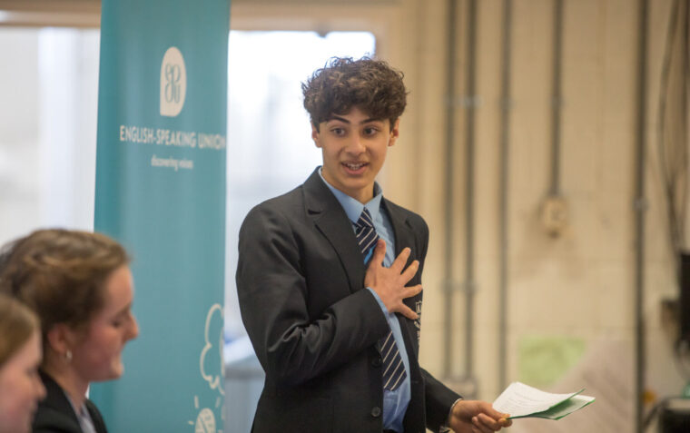 School boy talking passionately with hand on chest at ESU competition