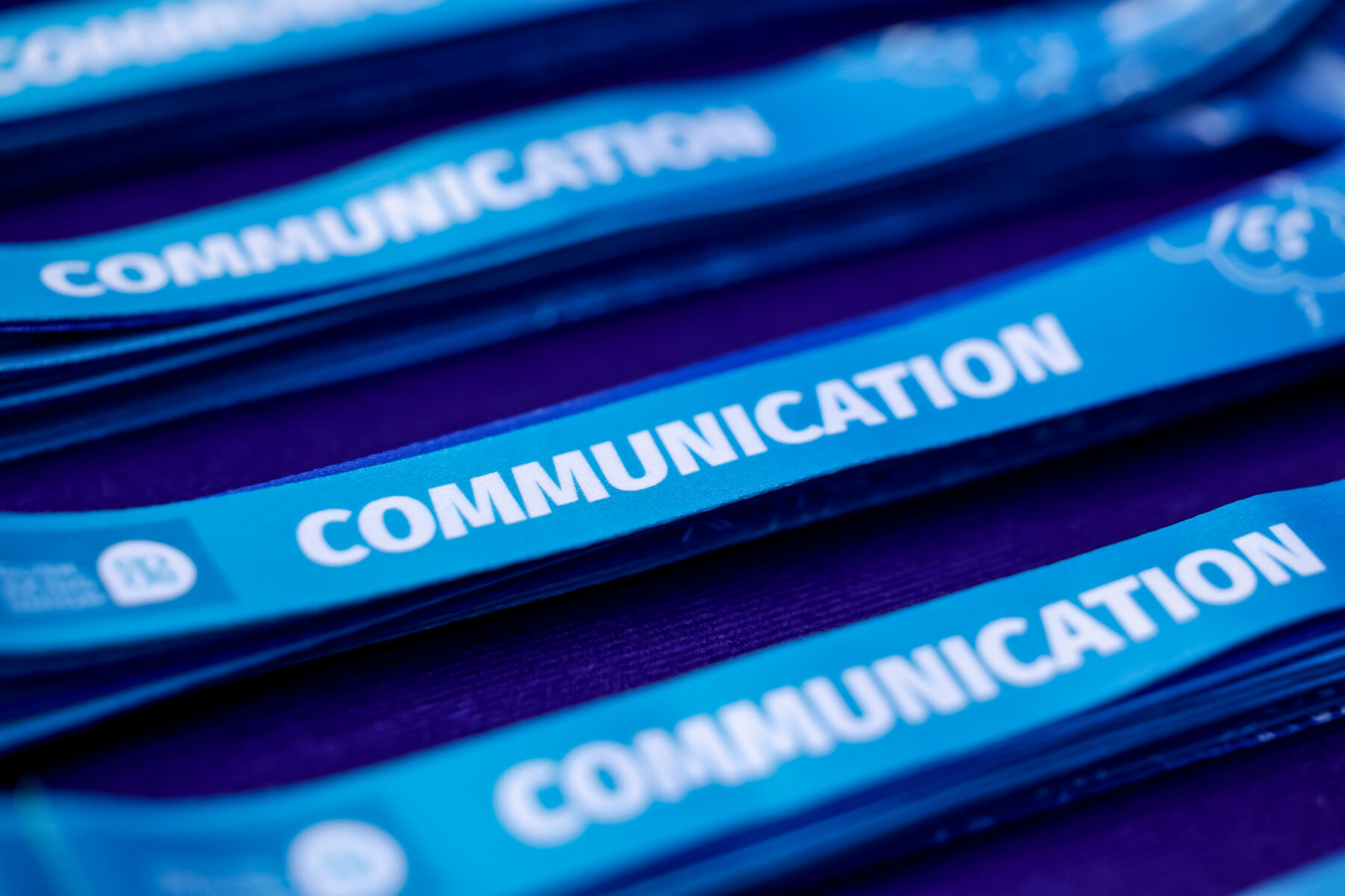 Blue ribbons lined up with the word 'communication' written on them.